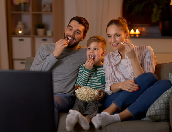 Family watching TV together on couch